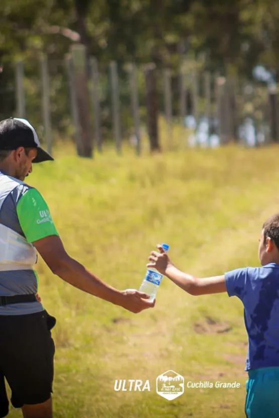 Adulto y un niño compartiendo una botella de agua